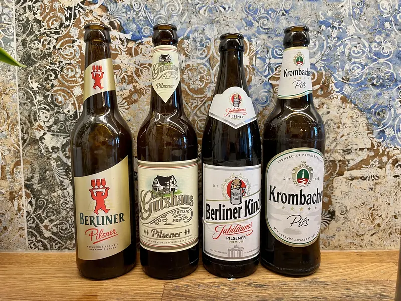 Four pilsner beer bottles
