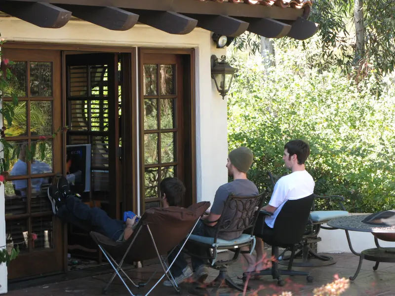 Three guys sitting outside the poolhouse